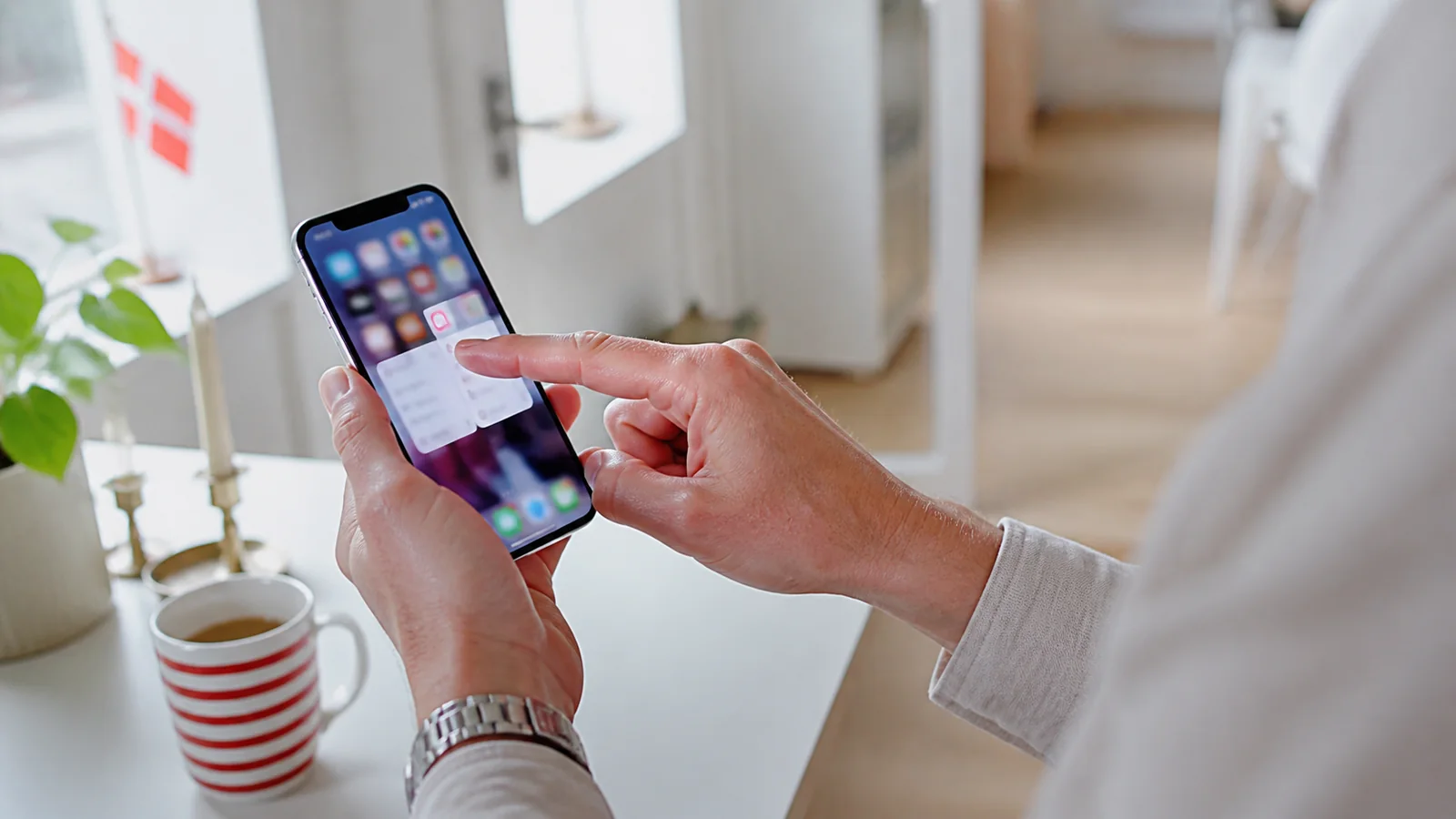 Voksen bruger føjer BetLabel til hjemmeskærmen på en iPhone