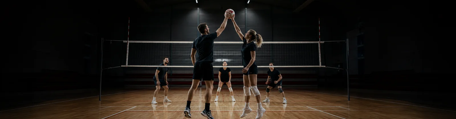 Voksne volleyballspillere midt i en dansk sportshal